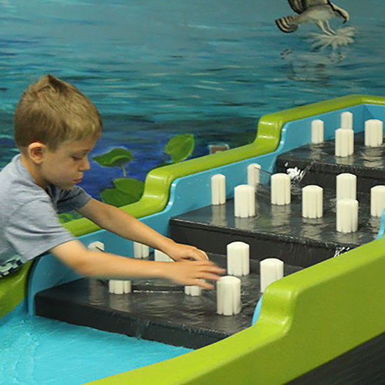 child playing with the La Crosse water table